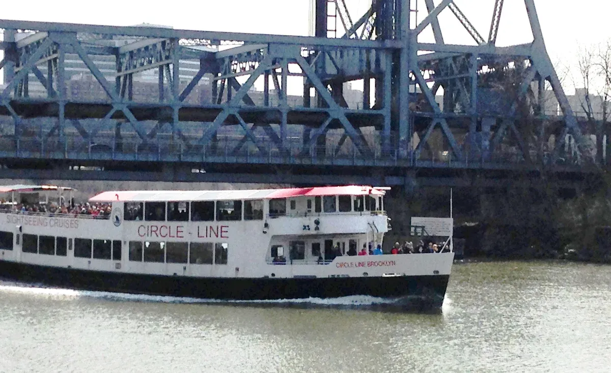 Circle Line boat on the Harlem River under the Broadway Bridge during a New York architecture boat tour